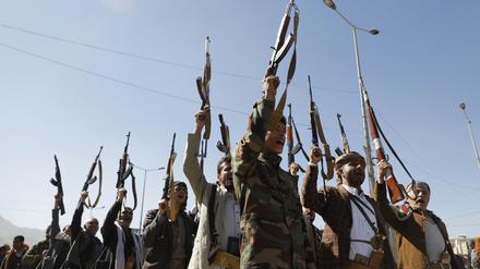 Neue Rekruten der Miliz der jemenitischen Huthi-Bewegung halten Waffen in die Höhe und skandieren Parolen, während sie sich versammeln.
