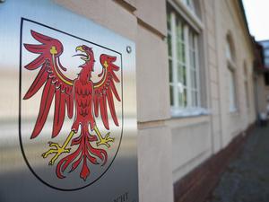 Das Landeswappen mit dem roten Adler hängt neben dem Eingang zum Brandenburger Verfassungsgericht. 
