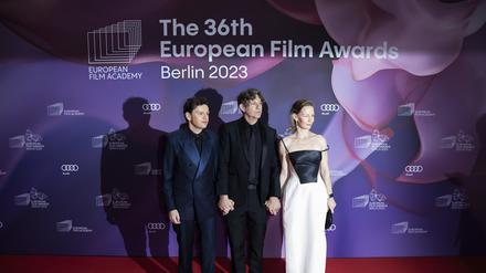 Christian Friedel (l-r), Schauspieler, Jonathan Glazer, Regisseur, und Sandra Hüller, Schauspielerin, kommen zur Verleihung des Europäischen Filmpreises. Die Europäische Filmakademie (EFA) vergibt die Auszeichnungen bei einer Gala in der Arena Berlin.