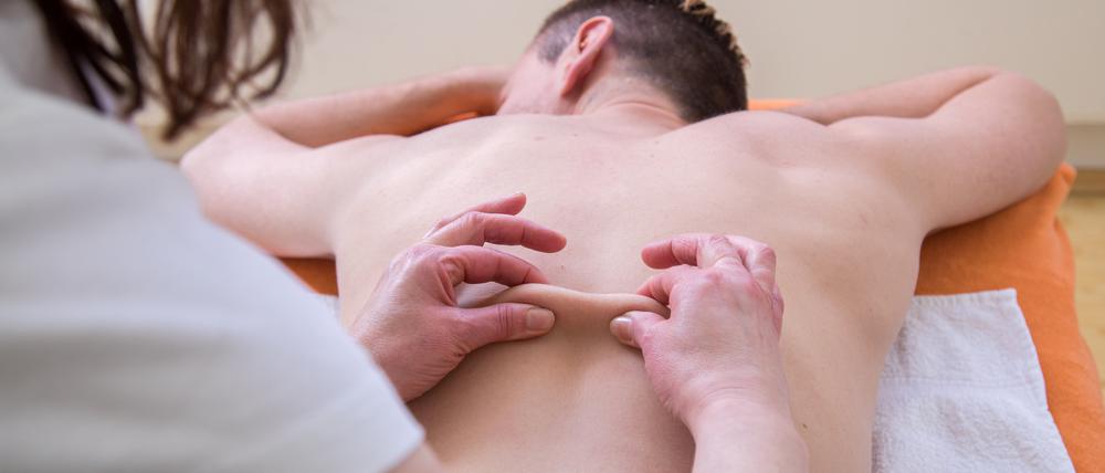 Ein Mann liegt auf einer Massageliege und erhält eine Massage.