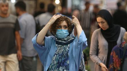 Eine Passantin in Teheran richtet sich ihre Kopfbedeckung.