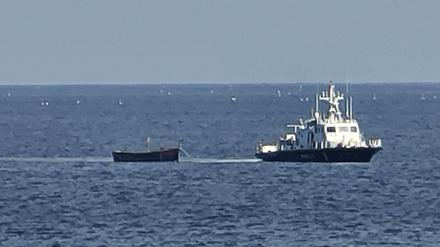 Ein Holzboot wird von einem südkoreanischen Militärschiff in Richtung eines Hafens in Yangyang in der Provinz Gangwon im Nordosten Südkoreas geschleppt.