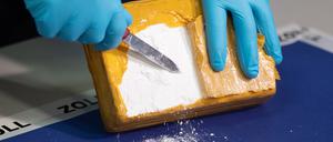 Ein Zollbeamter öffnet während einer Pressekonferenz in Hamburgein Paket mit Kokain, das von den Beamten sichergestellt wurde. 