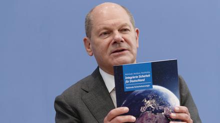Kanzler Olaf Scholz (SPD) mit der Broschüre zur neuen Nationalen Sicherheitsstrategie. 
