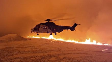 Ein Hubschrauber überfliegt einen Vulkanausbruch in Island.