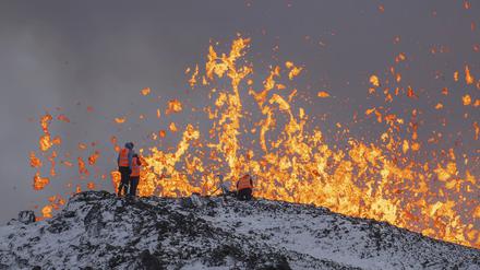 Wissenschaftler der Universität von Island nehmen Messungen und Proben, während sie auf dem Kamm vor dem aktiven Teil der Eruptionsspalte eines aktiven Vulkans in Grindavik auf der isländischen Halbinsel Reykjanes stehen. 