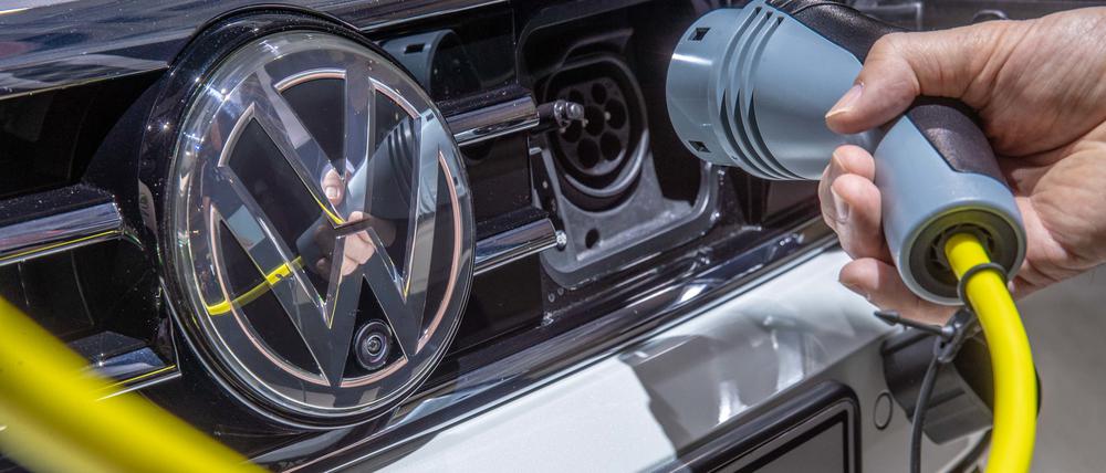 ARCHIV - 14.05.2019, Berlin: Ein VW-Mitarbeiter steckt bei der Volkswagen-Hauptversammlung ein Ladekabel an einem VW Passat. Europas größter Autobauer Volkswagen will gemeinsam mit Energiekonzernen ein europaweites Schnellladenetz für Elektroautos aufbauen. (zu dpa "VW will Schnellladenetz für E-Autos aufbauen - Aral wird Partner") Foto: Michael Kappeler/dpa +++ dpa-Bildfunk +++