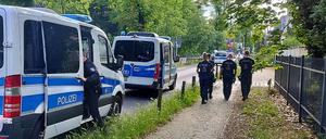 Polizisten gehen am abgesperrten Tatort in der Potsdamer Geschwister-Scholl-Straße entlang. 