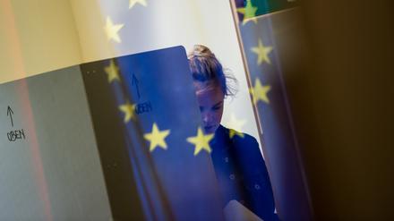 Eine junge Frau geht in einem Wahllokal in Berlin während der Europawahl aus der Wahlkabine. 