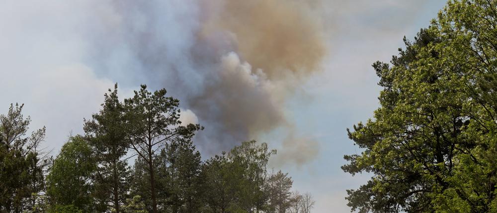 Ein Feuerwehrfahrzeug fährt durch einen Wald bei Jüterbog aus dem Rauchschwaden aufsteigen. Das Feuer in dem Wald hat sich wieder ausgebreitet.