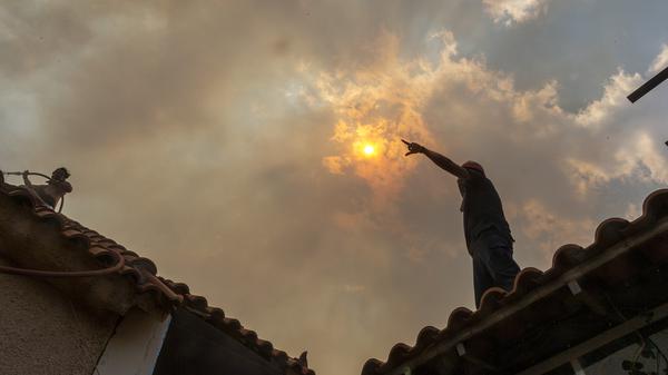 Freiwillige bekämpfen einen Waldbrand im Dorf Hasia in der Nähe von Athen, Griechenland.