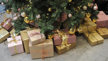 Weihnachtsgeschenke liegen unter einem Tannenbaum.