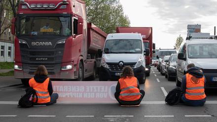Aktivisten der Gruppierung Letzte Generation blockieren eine Kreuzung an der Landsberger Allee. 