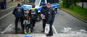 Polizisten entfernen einen Klimaaktivisten von einer Straße im Berliner Bezirk Schöneberg. (Archivbild)