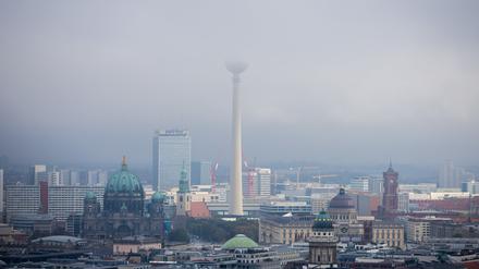 Der Berliner Fernsehturm verschwindet in tief hängenden Wolken. 