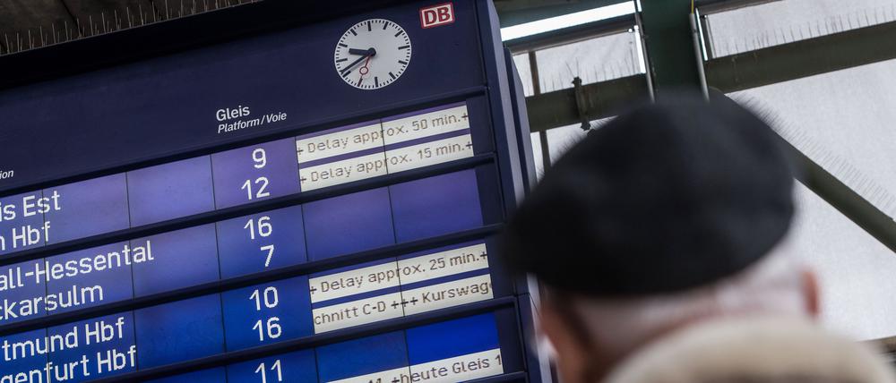 Ein Fahrgast schaut am Hauptbahnhof in Stuttgart zu einer Informationstafel der Deutschen Bahn, auf der Verspätungen bis zu 50 Minuten angezeigt werden. 