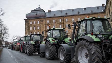 Mehrere Traktoren stehen am 16.01.2024 in Bad Staffelstein (Bayern) auf der Straße vor dem Kloster Banz.