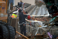 Ein Spurensicherer der Kriminalpolizei steht in den Trümmern eines explodierten Wohnhauses.