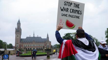 Ein Demonstrant hält ein Plakat hoch vor dem Internationalen Gerichtshof in Den Haag. 