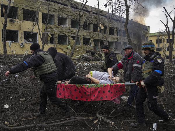 Ukraine, Mariupol: Ukrainische Rettungskräfte und Polizisten evakuieren die verletzte schwangere Frau Iryna Kalinina aus einer Entbindungsklinik, die durch einen russischen Luftangriff beschädigt wurde. (Archivbild vom 09.03.2022).