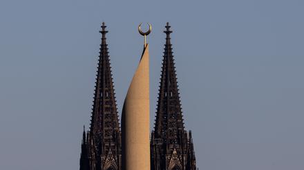 Das Minarett der Ditib-Zentralmoschee ragt vor den Türmen des Kölner Doms in den Himmel. Foto: Rolf Vennenbernd/dpa