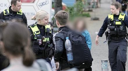 Polizisten geleiten Kinder von einer Schule in Neukölln weg. Zwei Schulkinder sind am Mittwoch in einer Schule in Berlin-Neukölln vermutlich von einem Mann verletzt worden.