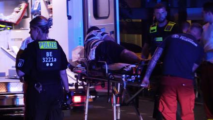 Sanitäter bringen in Berlin-Friedrichsfelde einen Verletzten auf einer Bahre zu einem Rettungswagen. 