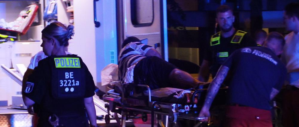 Sanitäter bringen in Berlin-Friedrichsfelde einen Verletzten auf einer Bahre zu einem Rettungswagen. 