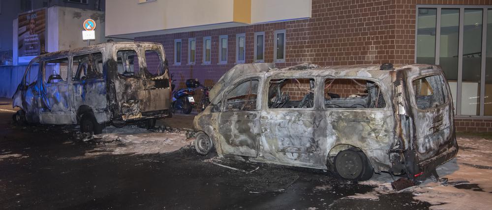Zwei ausgebrannte Polizeifahrzeuge stehen an der Wache der Polizeistation 55.