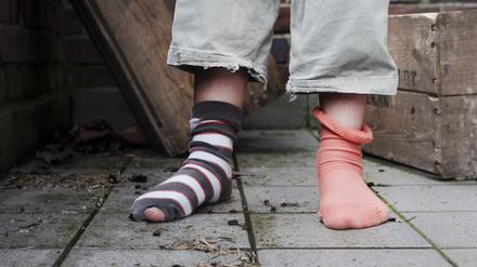 ARCHIV: Ein zehn Jahre altes Mädchen steht in abgetragener Kleidung ohne Schuhe in einem Hinterhof in Hamburg it