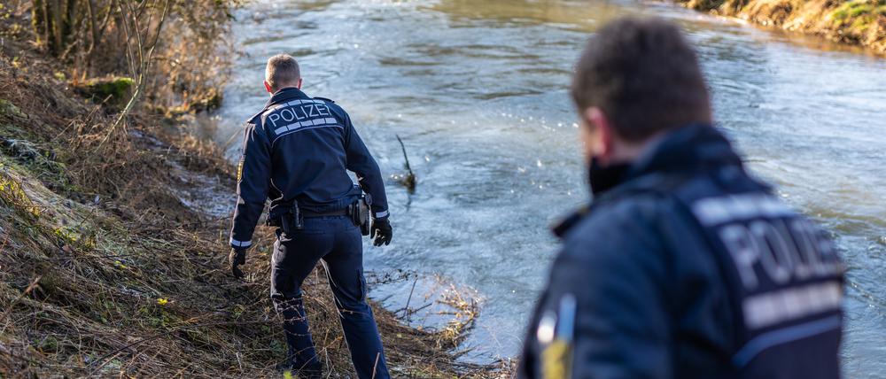 18.12.2023, Baden-Württemberg, Bingen-Hitzkofen: Einheiten der Polizei suchen am Ufer der Lauchert nach einem zweijährigen Kind.