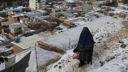 Eine Frau geht an einem kalten Wintertag in Fayzabad in der Provinz Badakhshan am 18. Januar 2023 einen Weg entlang.