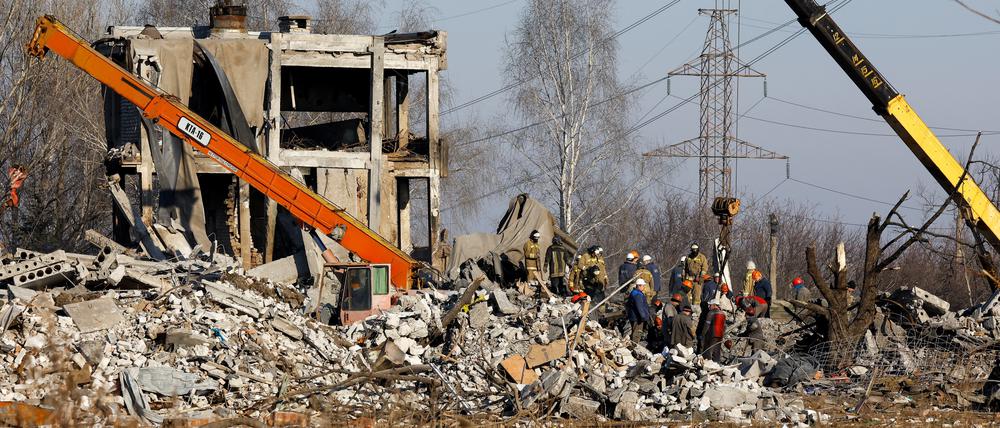 Arbeiter und Angehörige des Katastrophenschutzministeriums beseitigen die Trümmer eines zerstörten Gebäudes in der ostukrainischen Stadt Makijiwka.