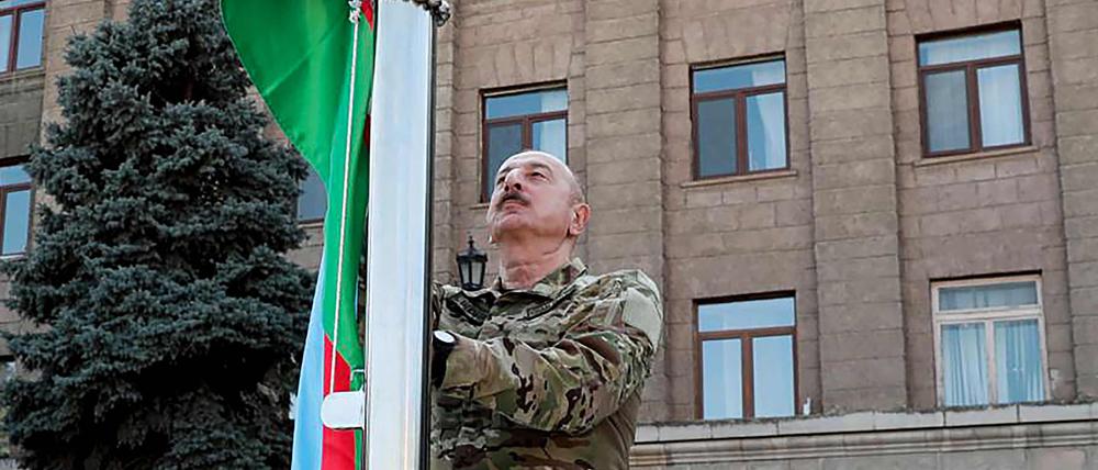 Der aserbaidschanische Präsidenten Ilham Aliyev hisst bei seinem Besuch in der Hauptstadt Bergkarabachs die aserbaidschanische Nationalflagge.