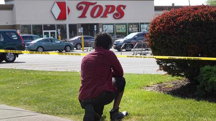 Eine Person kniet vor dem Tops-Markt in Buffalo, in dem ein Angreifer zehn Menschen erschossen hat (Archivbild).