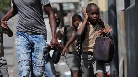 A child gestures as he looks for cover after leaving school amid gang violence in Port-au-Prince, Haiti March 3, 2023. REUTERS/Ralph Tedy Erol