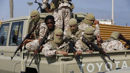 Anhänger von Dbeiba, einem der beiden rivalisierenden Ministerpräsidenten Libyens, sitzen bewaffnet auf der Ladefläche eines Fahrzeugs. Unklar ist, wer sich nahe Tripolis Kämpfe geliefert hat (Symbolbild).