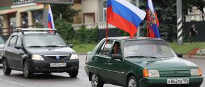 Menschen nehmen am Russland-Tag an einem Autokorso im besetzten Melitopol teil (Symbolbild).