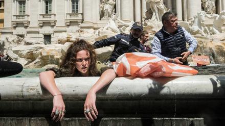 Klimaaktivisten der „Letzten Generation“ werden von Polizisten aus dem Wasser des Trevi-Brunnen geleitet.