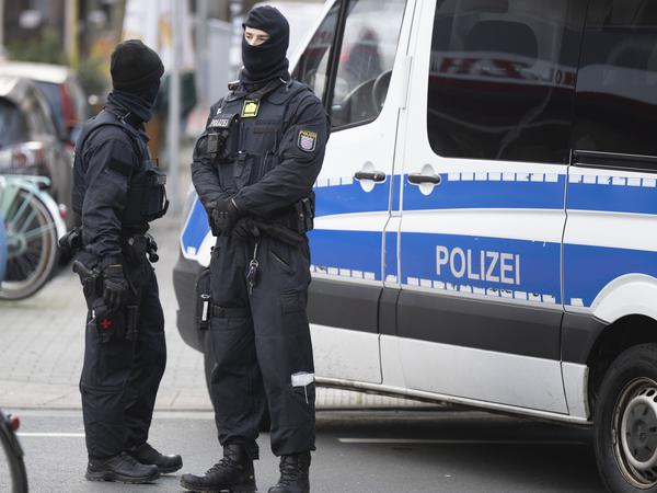 Bei einer Razzia gegen sogenannte „Reichsbürger“ stehen Polizisten an einem durchsuchten Objekt in Frankfurt am Main.
