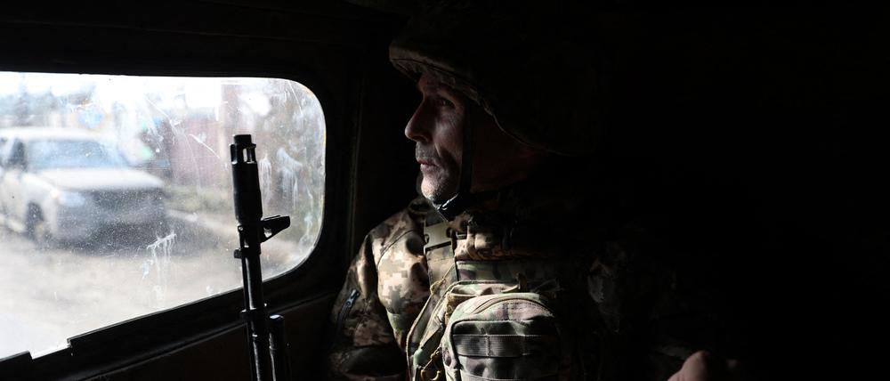 Ein ukrainischer Soldat schaut aus einem Fahrzeug während einer Fahrt durch Bachmut (Symbolbild).