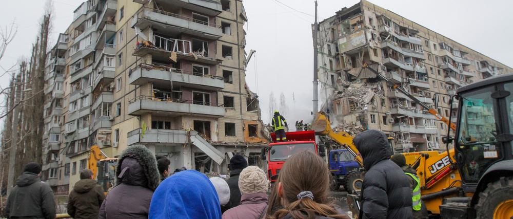 Menschen beobachten eine Such- und Rettungsaktion in dem Wohnblock in Dnipro, der von einer Rakete getroffen wurde (Archivbild).