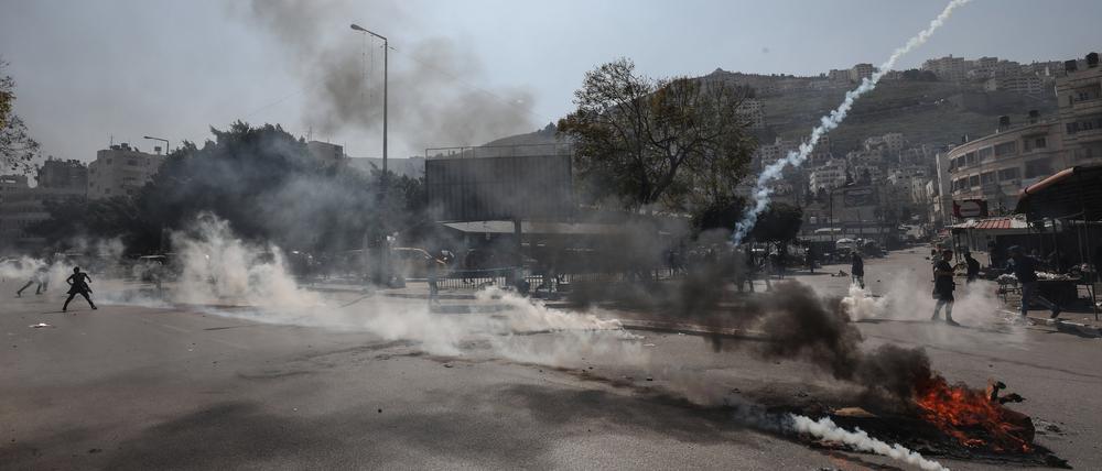 22.02.2023, Palästinensische Gebiete, Nablus: Israelische Streitkräfte feuern Tränengas auf palästinensische Demonstranten während den Zusammenstößen. Bei einem israelischen Militäreinsatz in Nablus im Westjordanland sind nach palästinensischen Angaben mindestens mehrere Palästinenser getötet worden. Foto: Ayman Nobani/dpa +++ dpa-Bildfunk +++