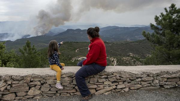 23.03.2023, Spanien, San Agustín: Eine Frau und ein Mädchen betrachten die Rauchschwaden in San Agustin, die durch den Waldbrand in Villanueva de Viver verursacht wurden. Das Fortschreiten des Großen Waldbrandes, von dem bereits 2000 Hektar zwischen Castellón und Teruel betroffen sind, hat die Evakuierung von einem Dutzend Dörfern erforderlich gemacht. Foto: Lorena Sopêna/EUROPA PRESS/dpa +++ dpa-Bildfunk +++