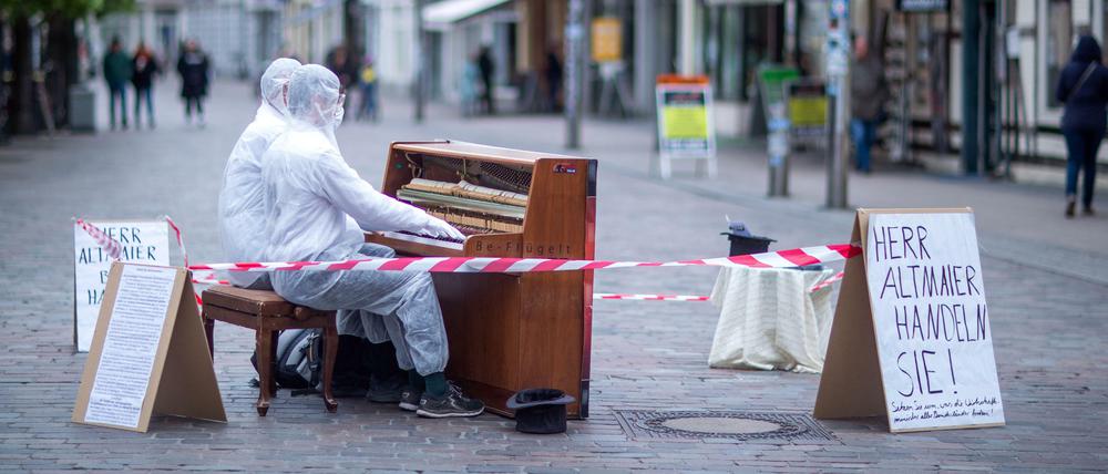 Die Musiker Julian Eilenberger (vorn) und Andreas Güstel spielen in der Mecklenburgstraße auf ihrem mobilen Klavier.