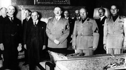 Adolf Hitler (m.) steht zwischen Neville Chamberlain (ganz links) und Benito Mussolini (r.).