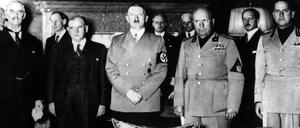 Adolf Hitler (m.) steht zwischen Neville Chamberlain (ganz links) und Benito Mussolini (r.).