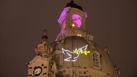 Eine Friedenstaube ist am 26.01.2015 an der Kuppel der Frauenkirche nahe der Bühne während eines Konzerts für Weltoffenheit und Toleranz auf dem Neumarkt in Dresden (Sachsen) zu sehen.