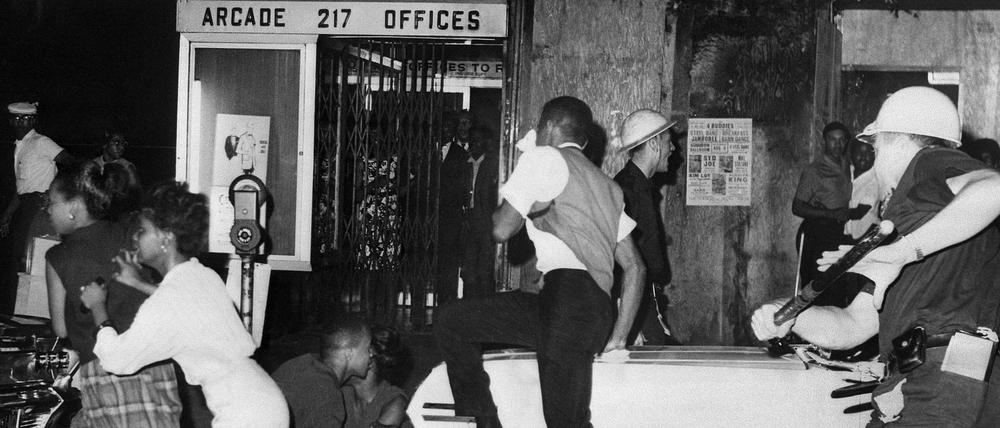 Auf der Flucht: Ein Polizist jagt Bewohnerinnen und Bewohner Harlems am 20. Juli 1964. 