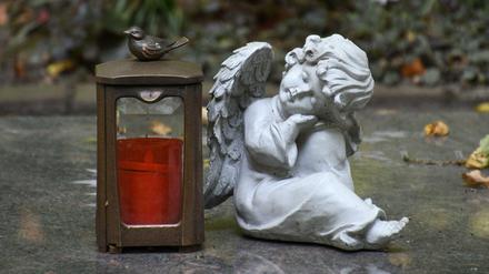 Ruhe in Frieden. Eine Engelsfigur auf einem Grabstein im Waldfriedhof.